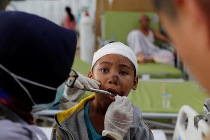 Los paramédicos dan tratamiento a un sobreviviente del terremoto en el hospital de Tanjung.