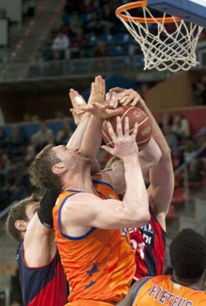 El pivot del Valencia Basket Serhiy Lischchuk intenta un lanzamiento ante el alero del Caja Laboral Andrés Nocioni.