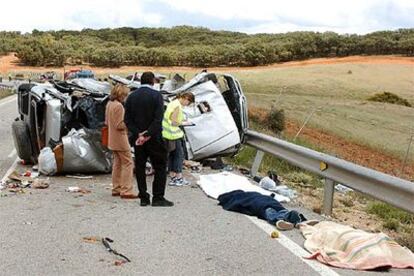 Tres de las víctimas del accidente yacen junto a los restos de los vehículos.