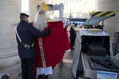 El voluntario Wolfgang Kimmig-Liebequien que hace de Santa Claus desde hace años, es cacheado por un policía antes de entrar en la plaza de San Pedro en en Vaticano, antes de asistir a una audiencia general con el Papa Francisco.