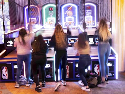 Un grupo de chicas juega en unos recreativos.