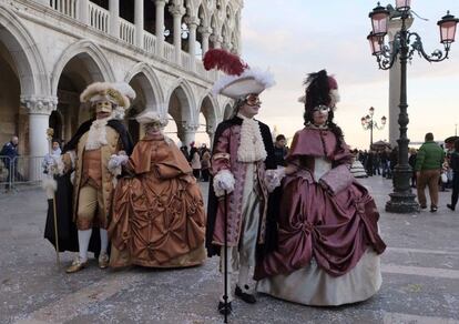 Um grupo fantasiado com roupas de época passeando pela praça de São Marcos de Veneza.