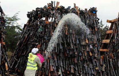 El vicepresidente William Ruto presidió el incendio de rifles y pistolas en tres pilas de aproximadamente 4 metros de altura. En la imágen, un trabajador vierte gasolina sobre las armas, en Ngong (Kenia).