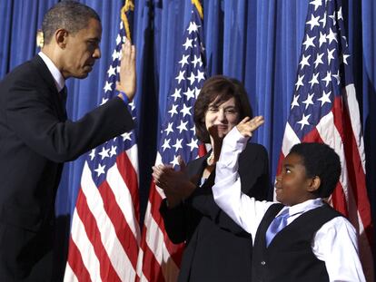 Obama choca su mano con la de Marcelas Owens tras la firma de la ley sanitaria.