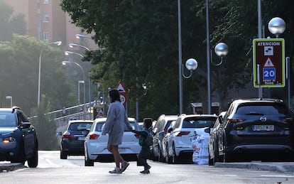 Una madre lleva a su hijo al colegio Ciudad de Roma por la calle de Juan Esplandiú, en el distrito de El Retiro, en la que antes se cortaba el tráfico.