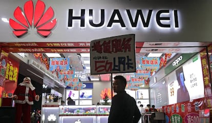 Un hombre pasea junto a una tienda con un logotipo de Huawei en China.