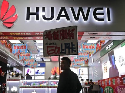 Un hombre pasea junto a una tienda con un logotipo de Huawei en China.