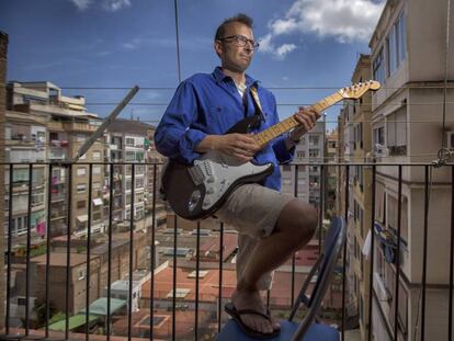 Oriol Guillén tocant la guitarra al balcó de casa seva.
