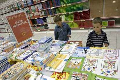 Unos niños miraban ayer libros de texto, a la venta en una gran superficie de San Sebastián.