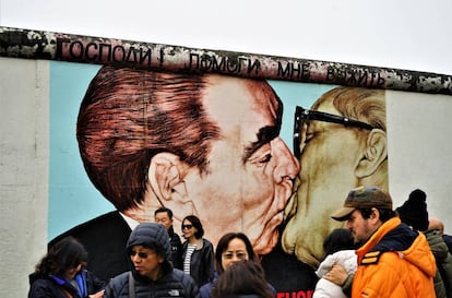 Turistas frente al beso de Brezhnev y Honecker.