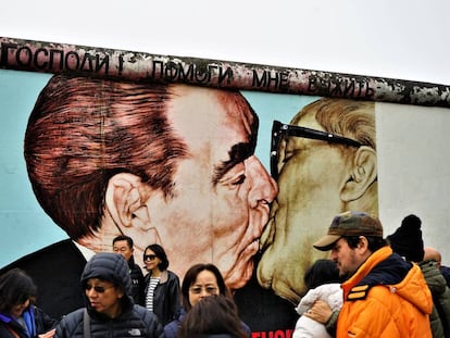 Turistas frente al beso de Brezhnev y Honecker.