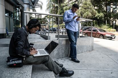 Dos personas tratan de conectarse a Internet en Caracas durante un apagón en abril de 2019.