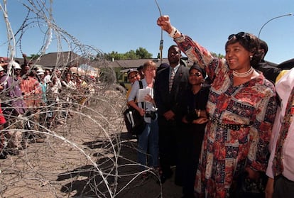 Winnie Madikizela-Mandera, ex mujer del presidente surafricano Nelson Mandela, saluda a sus seguidores detrás de una valla de espino, en un fracasado encuentro con el hombre de negocios blanco Piet Odendaal, en Viljoenskrron, en el estado libre de Orange, Suráfrica, en noviembre del 2000.