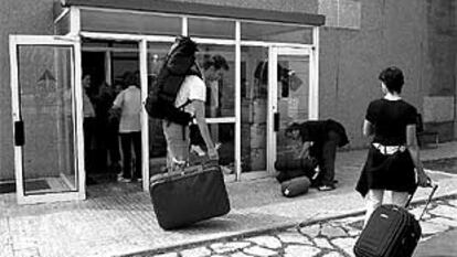 Pasajeros con destino a Barcelona recogen sus maletas perdidas en el aeropuerto de El Prat.