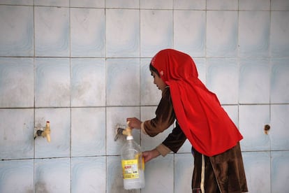 Una ni&ntilde;a rellena una botella en Islamabad.
 