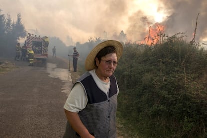 Los cinco incendios activos en la mañana de este miércoles en la provincia de Ourense han calcinado más de 3.250 hectáreas en apenas un día, según la información actualizada que remite la Consellería de Medio Rural. En la imagen, una vecina del pueblo de Requías en donde ha sido necesario decretar medidas preventivas por cercanía del fuego a las casas, el 6 de septiembre.