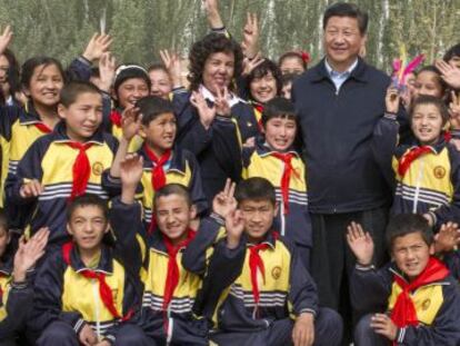 El presidente Xi Jinping posa con unos estudiantes durante su visita a la regi&oacute;n de Xinjiang.