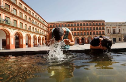 Unos niños se refrescan en una fuente de la Plaza de La Corredera de Córdoba, el pasado viernes. 