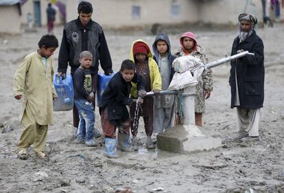 Niños beben de una fuente pública en las afueras de Kabul (Afganistán).