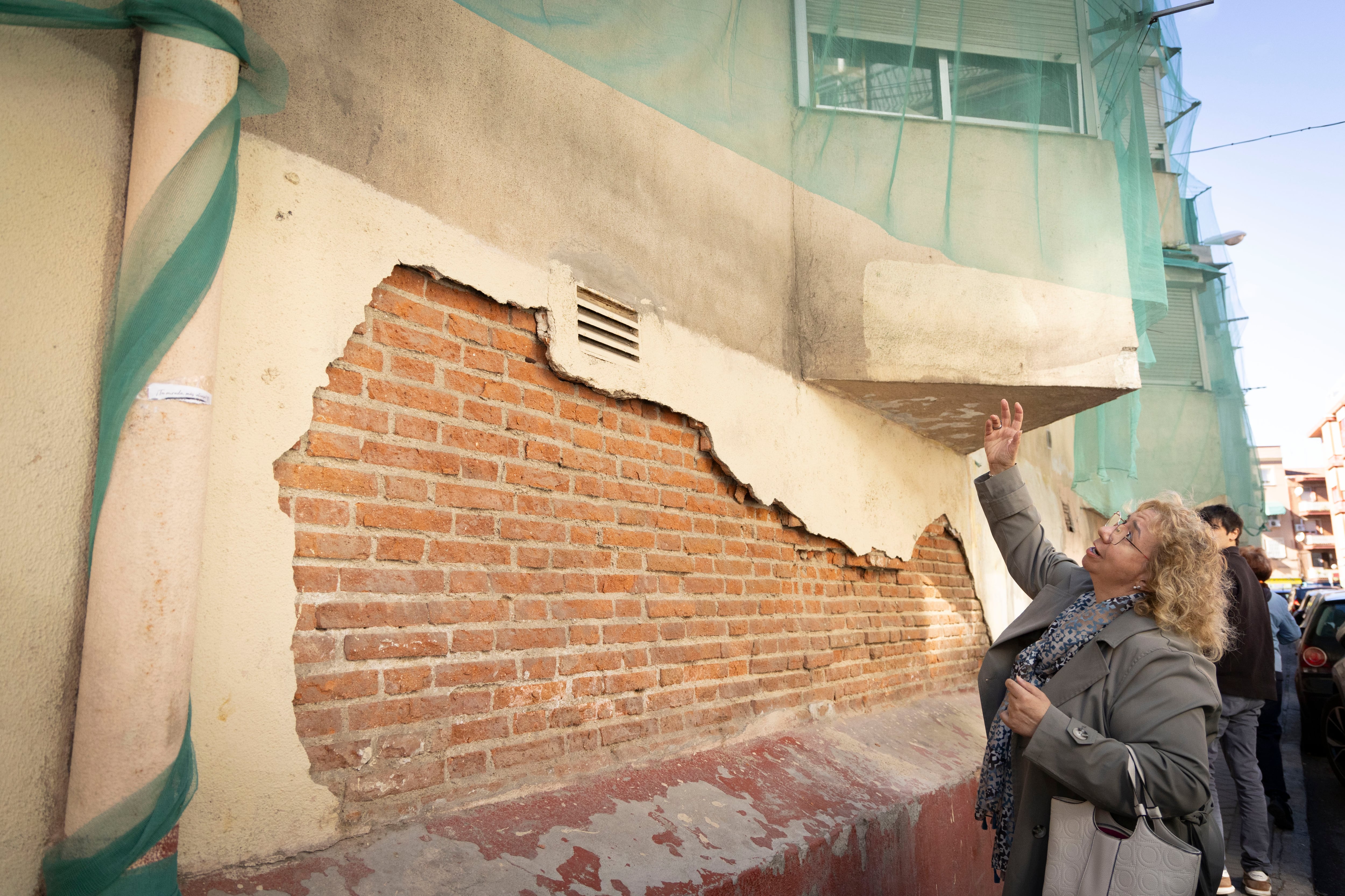 Ana Alonso, representante de la asociación vecinal, muestra los desperfectos en uno de los edificios de la Colonia Experimental de Villaverde.
