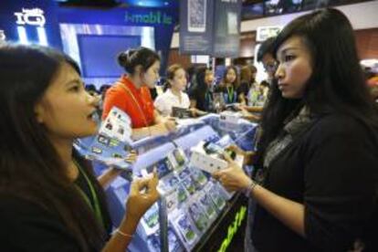 Una visitante adquiere un teléfono móvil en la Thailand Mobile Expo 2013 en Bangkok (Tailandia). EFE/Archivo