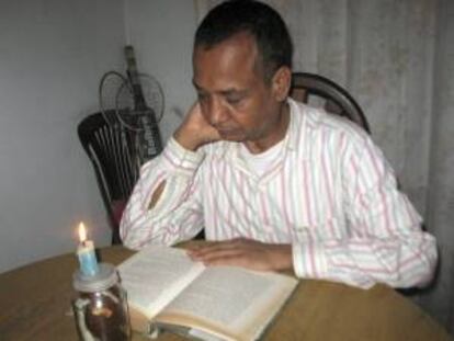 Un ciudadano nepalí se ayuda de la luz de una vela para leer durante uno de los frecuentes apagones que padece el país, el pasado 18 de septiembre de 2012. Para ahorrar energía eléctrica, el Gobierno de Nepal ha decidido que habrá dos días de descanso por semana, en lugar de solo uno.