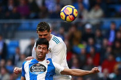 Cristiano Ronaldo, del Real Madrid, y Juan Francisco Moreno, del Deportivo, cabecean para hacerse con el balón.