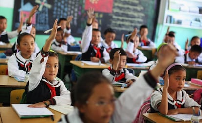 Los estudiantes de una clase de lengua tibetana levantan la mano para responder una pregunta en el colegio experimental de educación primaria de Lhasa, capital de la región autónoma de Tíbet, en junio de 2009.