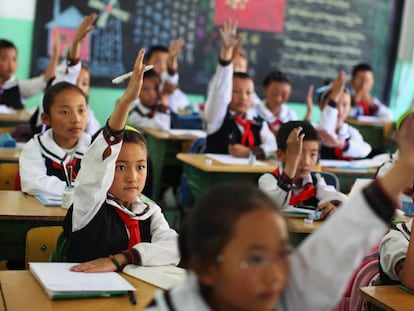 Los estudiantes de una clase de lengua tibetana levantan la mano para responder una pregunta en el colegio experimental de educación primaria de Lhasa, capital de la región autónoma de Tíbet, en junio de 2009.