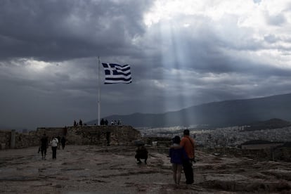 Una bandera griega ondea en la colina de la antigua Acrópolis, en Atenas.