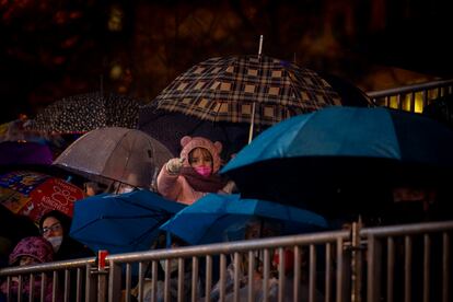 Una niña entre los paraguas durante la Cabalgata de los Reyes Magos de 2022 en Madrid.