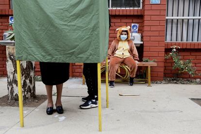 Un niño observa a su madre emitir su voto en Temuco, Chile, el pasado 17 de mayo.