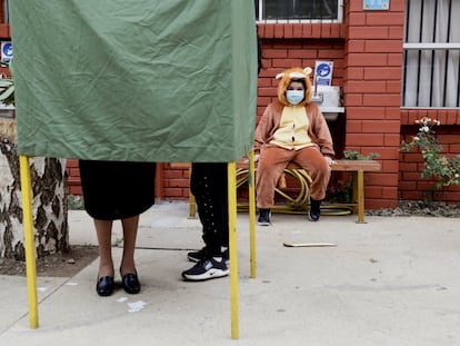 Un niño observa a su madre emitir su voto en Temuco, Chile, el pasado 17 de mayo.