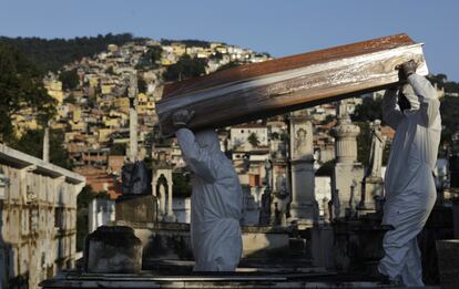 Los sepultureros trasladan el ataúd de una fallecida por coronavirus este lunes en Río de Janeiro.