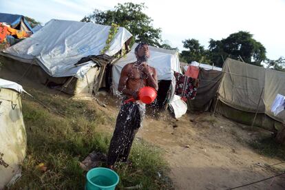 A falta de agua corriente, los habitantes de los campos de desplazados utilizan pozos y se bañan donde pueden, como este hombre.