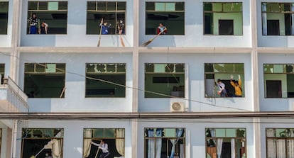 Personas limpian un edificio dañado después de un bombardeo en Lashio (Birmania).