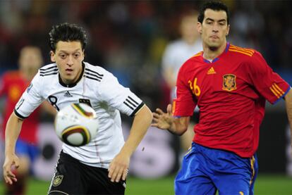Özil persigue el balón junto a Sergio Busquets durante el encuentro de semifinales del Mundial.