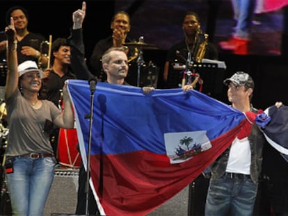 Milly Quezada, Miguel Bosé, Alejandro Sanz, Juanes, Luis Fonsi y Juan Luis Guerra sostienen la bandera de Haití y de la República Dominicana al final del concierto.