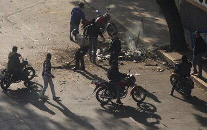 Los agentes de las fuerzas de seguridad y los civiles armados retiran las barricadas colocadas por manifestantes opositores. El primer grupo de civiles llegó en motos de baja cilindrada, cargando pistolas y vestidos de negro. Solo uno solo llevaba la macabra máscara de la muerte similar la que usan funcionarios del DGCIM , la contrainteligencia militar.