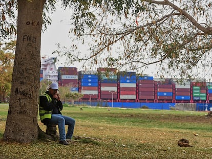 Un trabajador, frente a un buque que atraviesa este martes el canal de Suez.