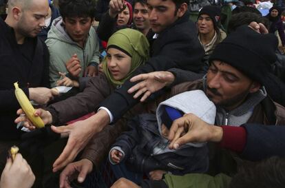 Migrantes reciben alimentos este martes en el puerto de El Pireo (Grecia).