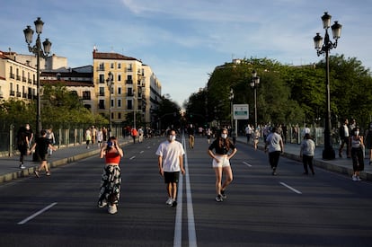 Varias personas caminan el pasado domingo por la calzada para mantener la distancia en el viaducto de Segovia, en Madrid.