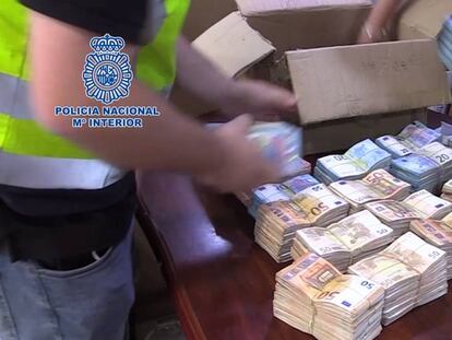 Los agentes de la Policía Nacional requisan varios fajos de billetes.