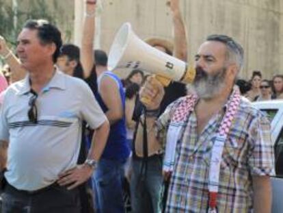 El diputado de IULV-CA y alcalde de Marinaleda (Sevilla), Juan Manuel Sánchez Gordillo (d), en el exterior del establecimiento donde 200 militantes del Sindicato Andaluz de Trabajadores (SAT) entraron ayer en Écija (Sevilla) para llevarse alimentos de primera necesidad destinados a un comedor social de Sevilla.