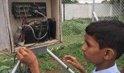 El estudiante Vamshi Voggu revisa la estación meteorológica instalada en el colegio de Kothapalli, India.