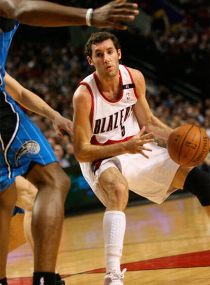 El jugador español Rudy Fernández de los Trail Blazers de Portland trata de pasar la marca a un jugador de los Magic de Orlando.