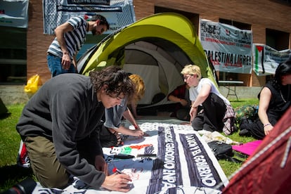 Estudiantes madrileños acampados en la Universidad Complutense pintan una pancarta en favor de Palestina.