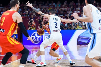 El base de la selección española Sergio Llull (en el centro) presionado por el argentino Luca Vildoza.