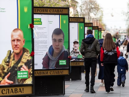 Vecinos de Bucha pasaban en marzo junto a carteles con imágenes de los soldados caídos en esa localidad ucrania cercana a Kiev.