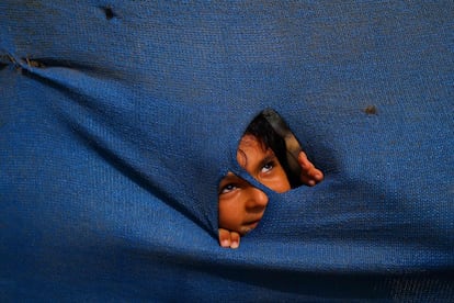 Una niña palestina observa a través de una lona cerca de su casa en Gaza.